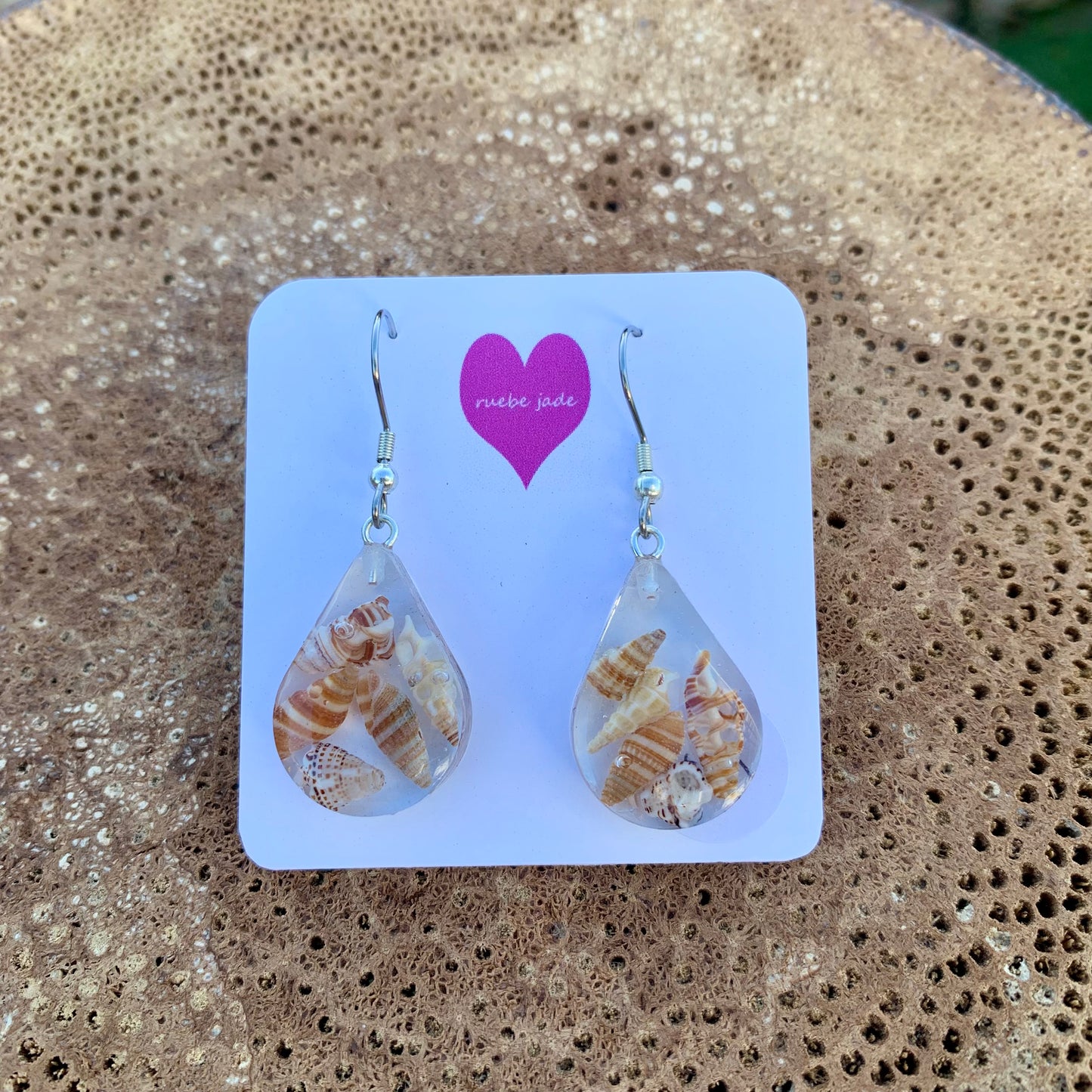 Tear drop earrings made from resin featuring real sea shells.