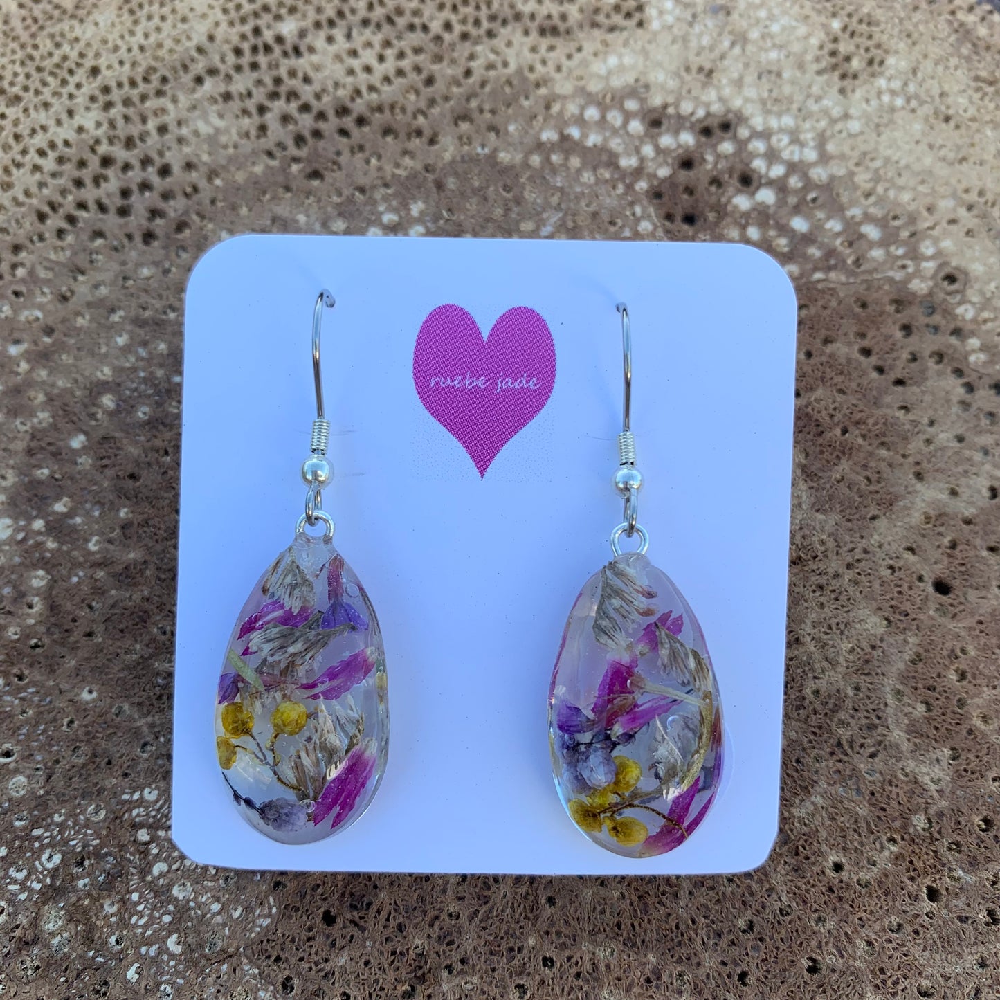 Teardrop dangle earrings made with resin and real flowers. 