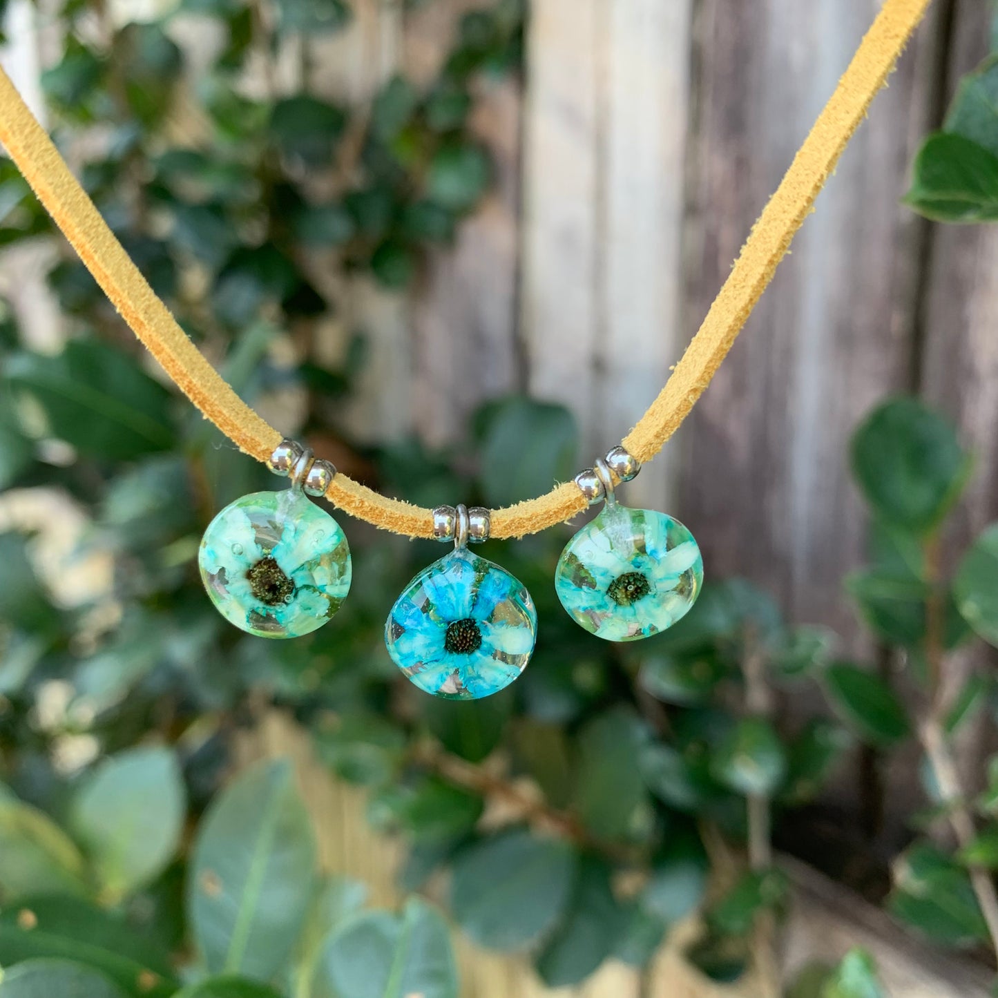 Blue daisy flowers on a vegan suede cord.