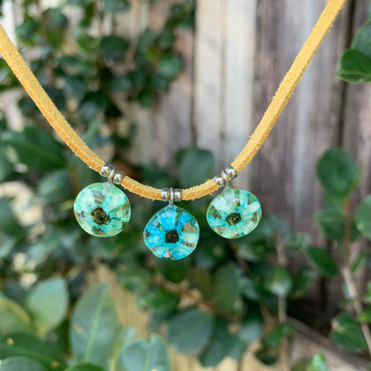 Blue daisy flowers on a vegan suede cord.