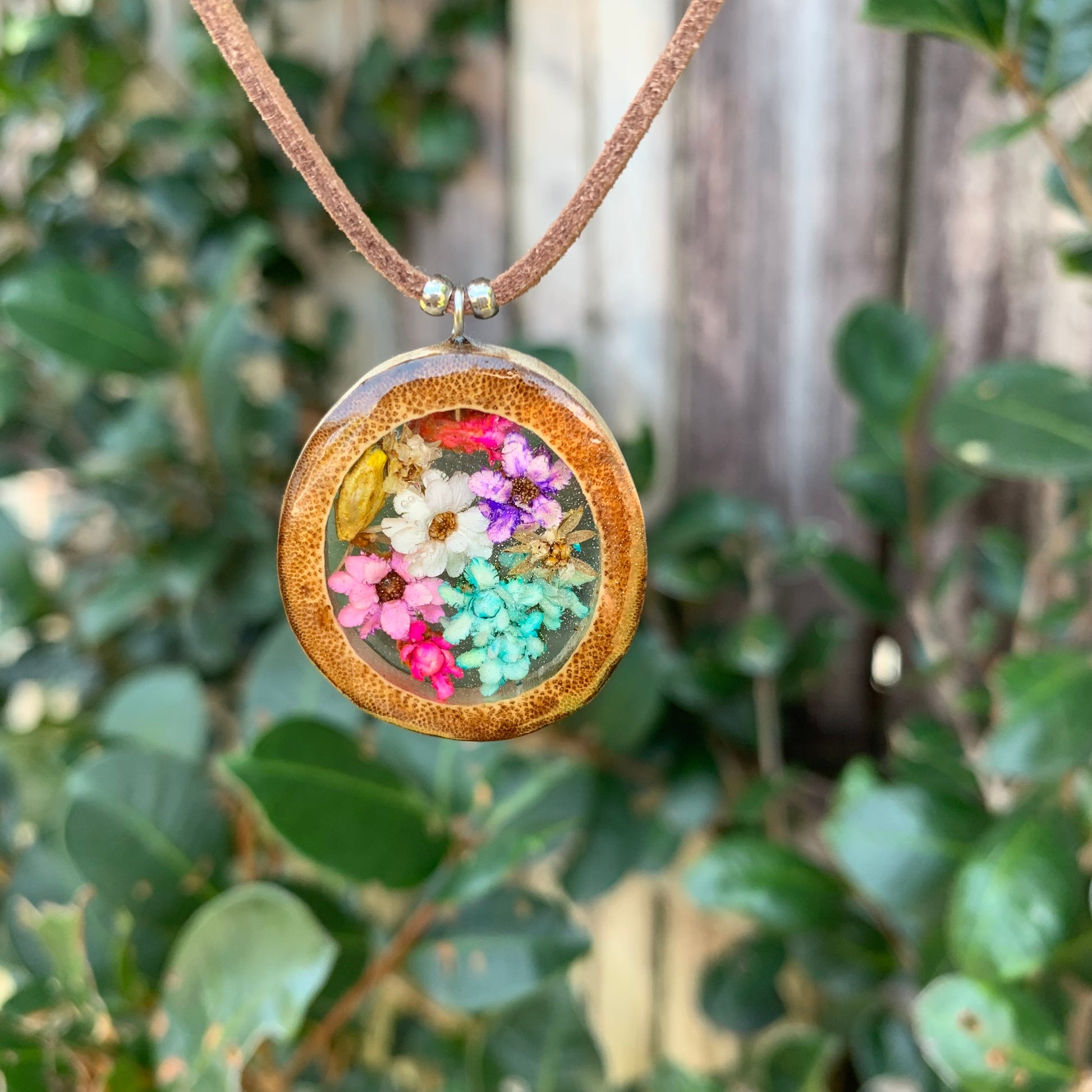 Necklace with a round pendant featuring colourful flowers.